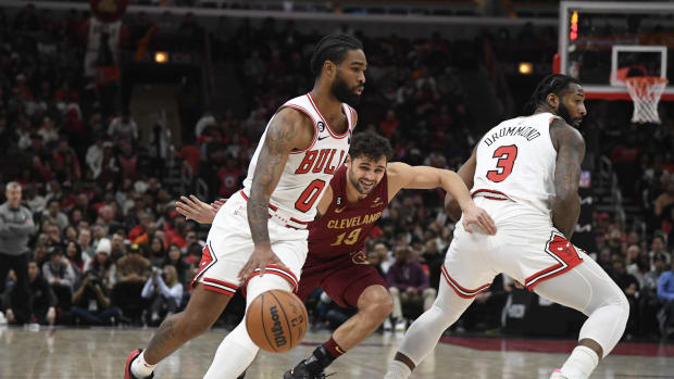 Chicago Bulls guard Coby White (0) moves the ball against Cleveland Cavaliers guard Raul Neto (19) as Chicago Bulls center Andre Drummond (3)
